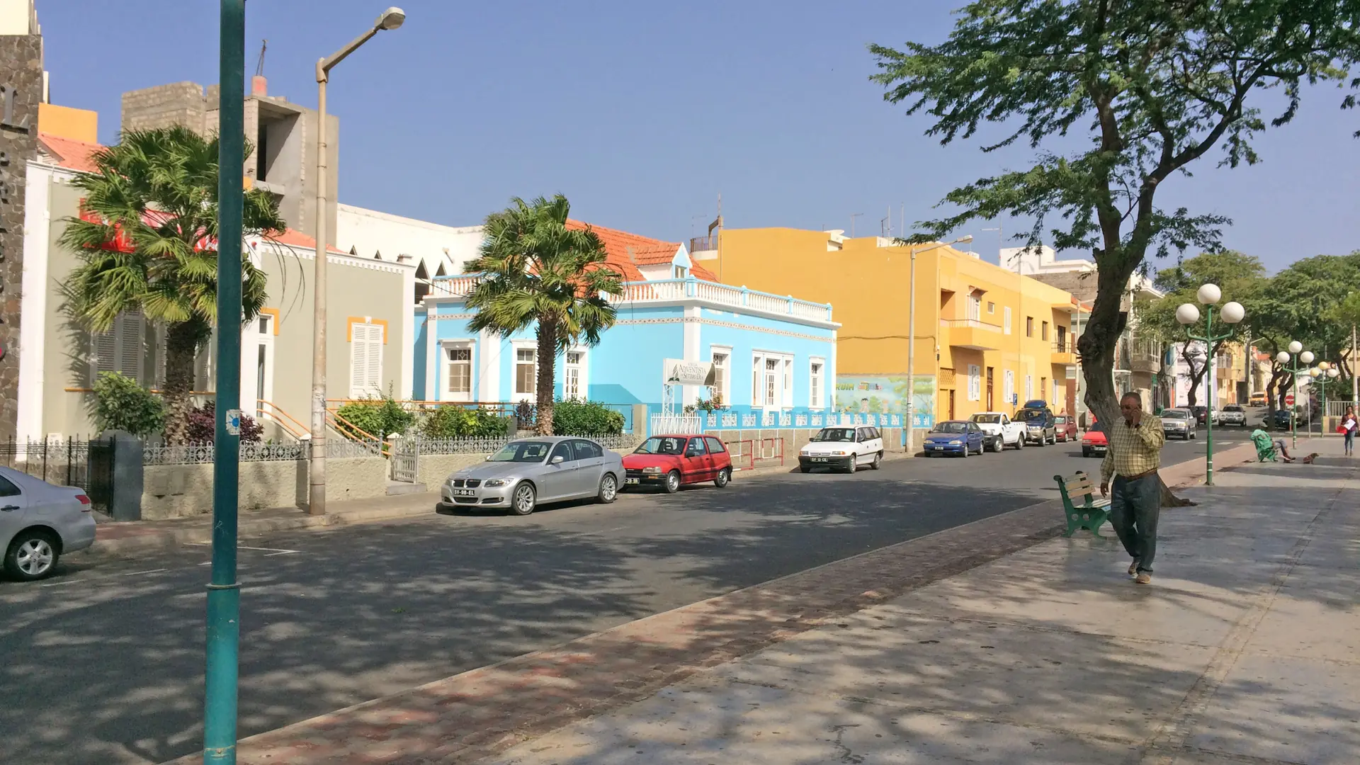Colourful buildings and shaded pavement on Avenida 5 de Julho in Mindelo