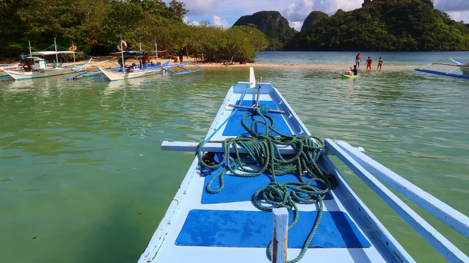 An outrigger bangka beside the Snake Island sandbar near El Nido in daylight