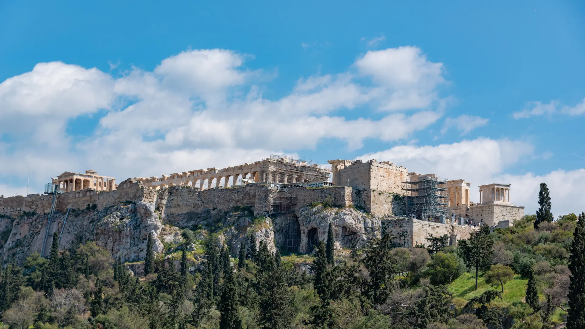 The Acropolis and Parthenon rising above Athens beneath a bright blue sky
