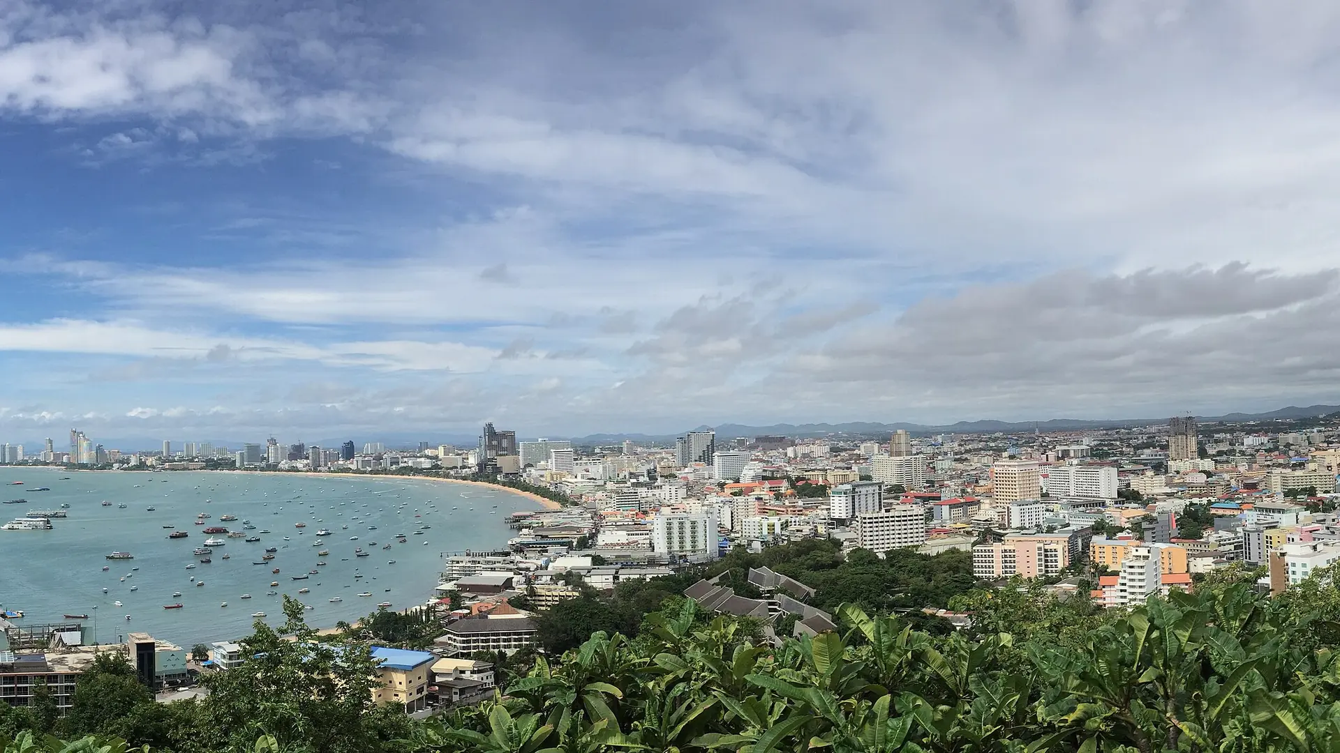 Daylight panorama across Pattaya Bay and the city beneath a blue sky