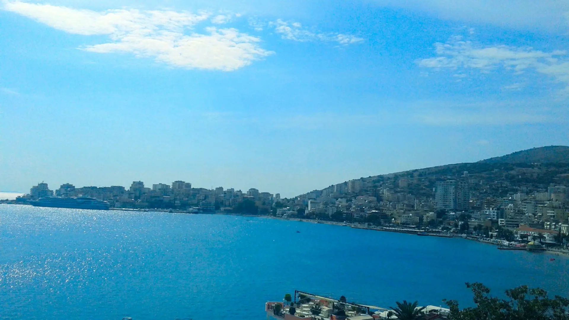 Sarandë's hillside town wrapping around its blue bay on a clear day