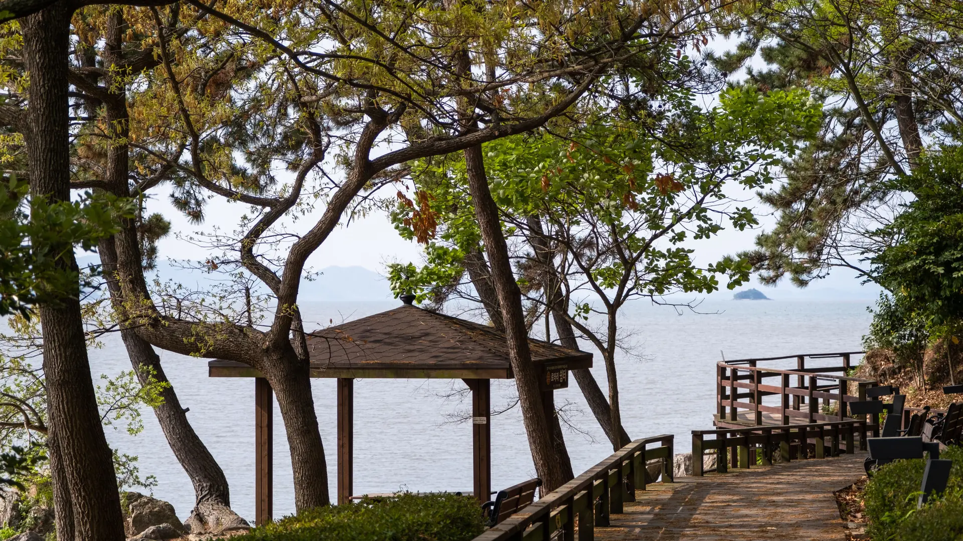 A wooden pavilion overlooking the sea in a hillside park in Incheon