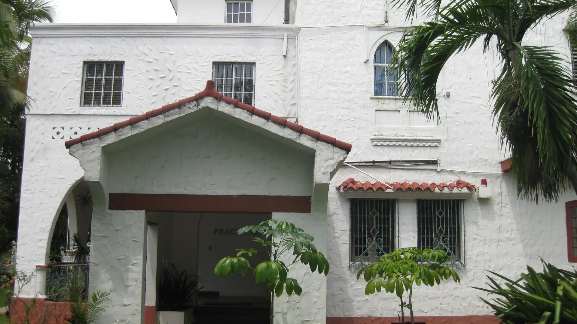 White Gazcue house and palms in daylight in Santo Domingo