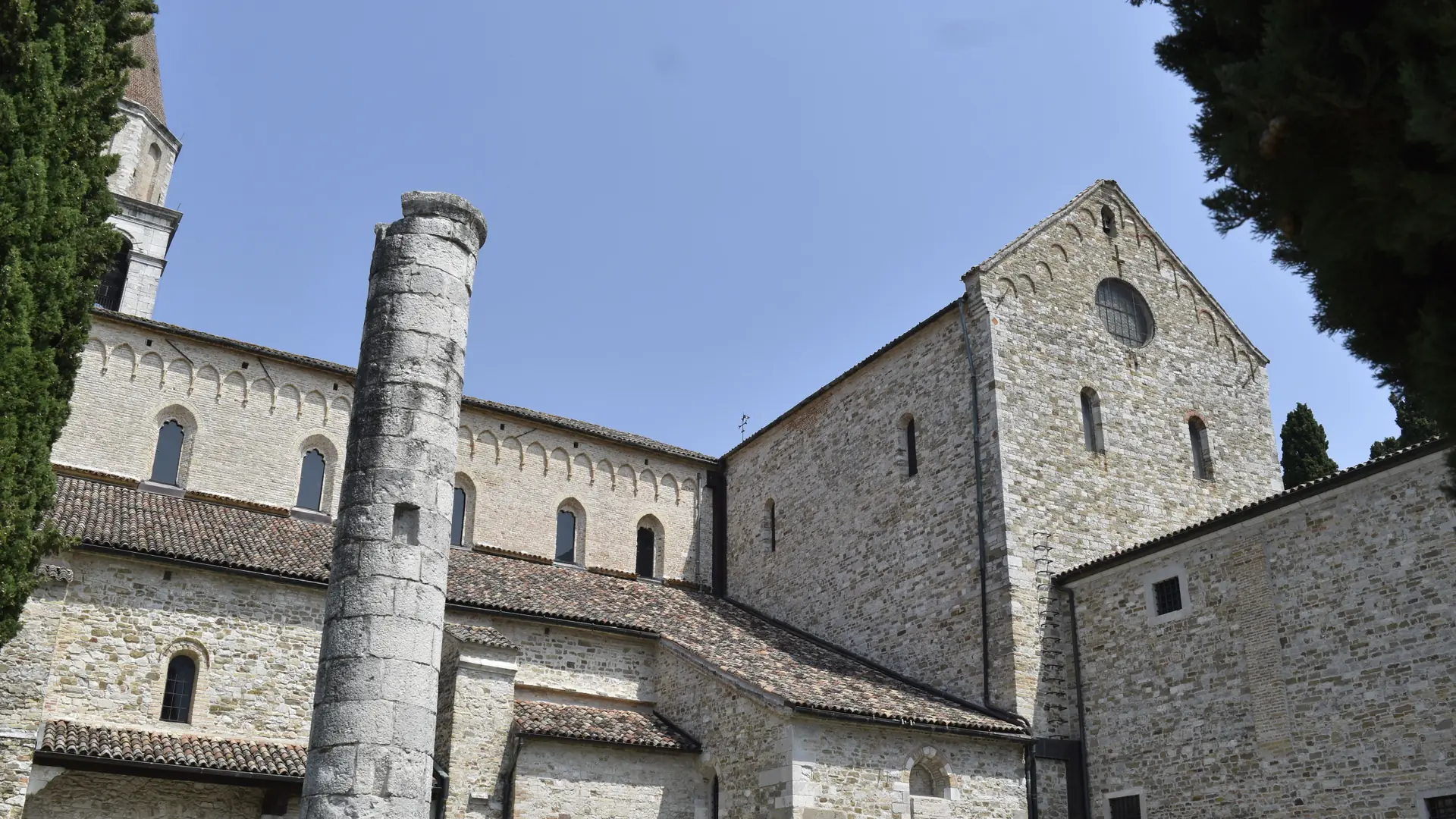 the Romanesque stonework of San Zeno Basilica in Verona under a clear blue sky