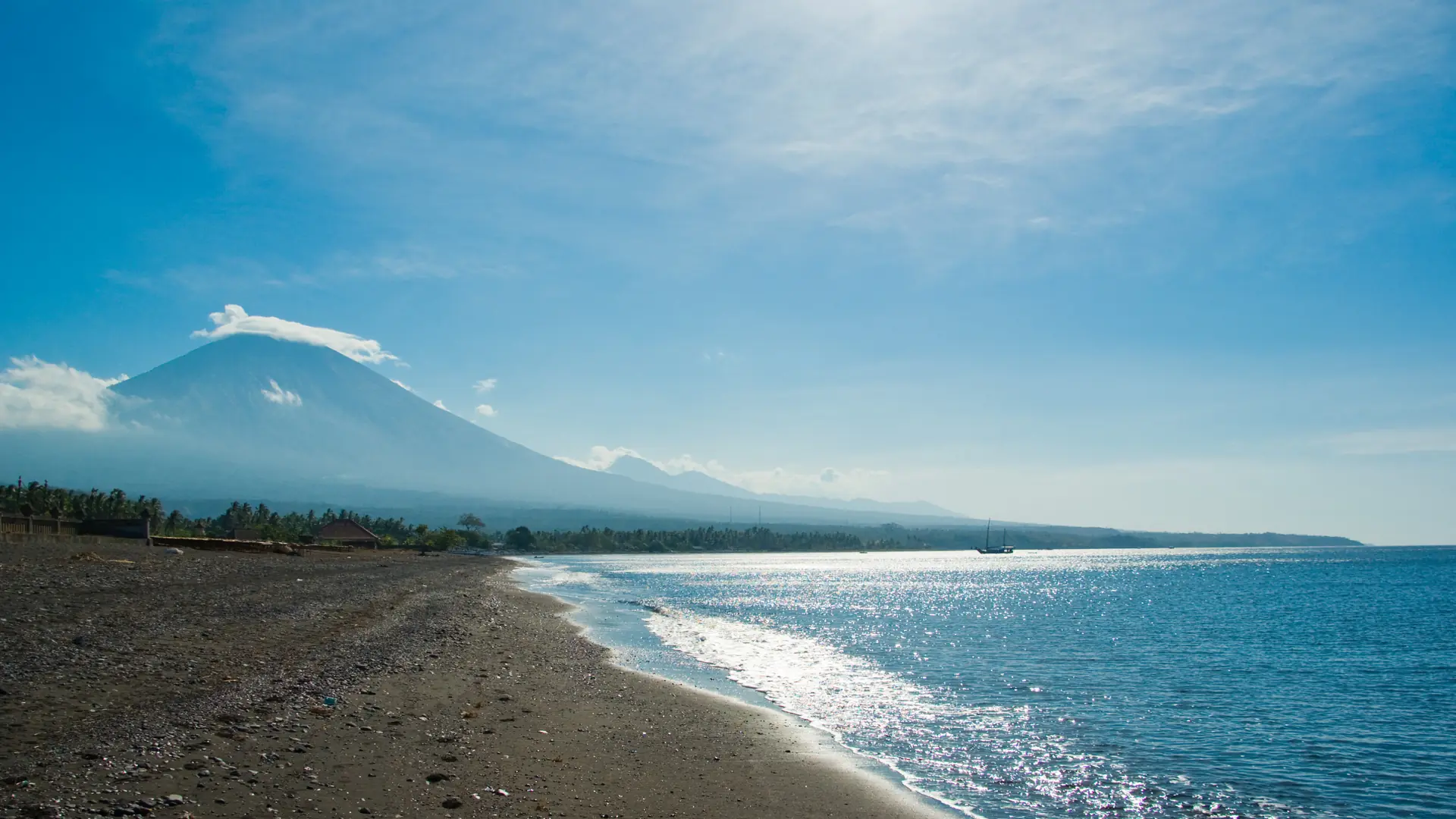 Mount Agung beyond Amed’s dark-sand beach and blue water