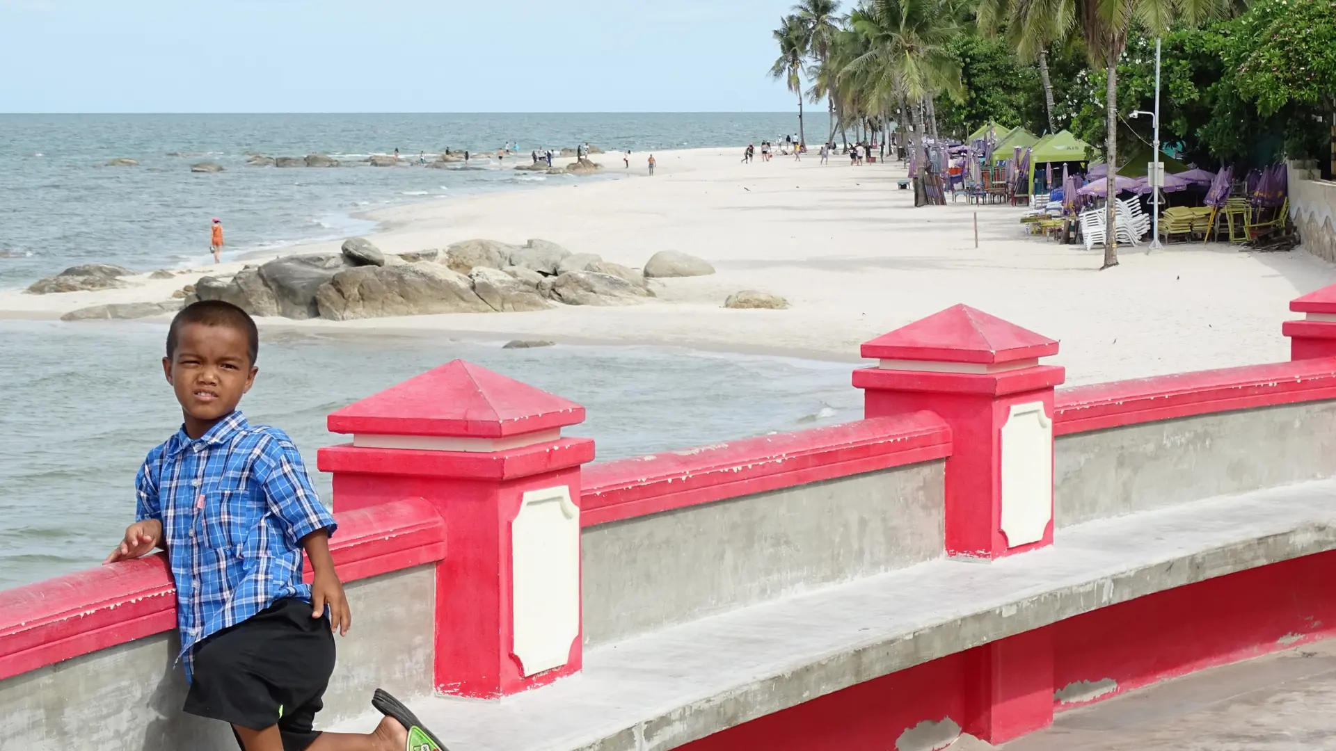 A quiet stretch of Hua Hin shoreline with palms and shallow Gulf water