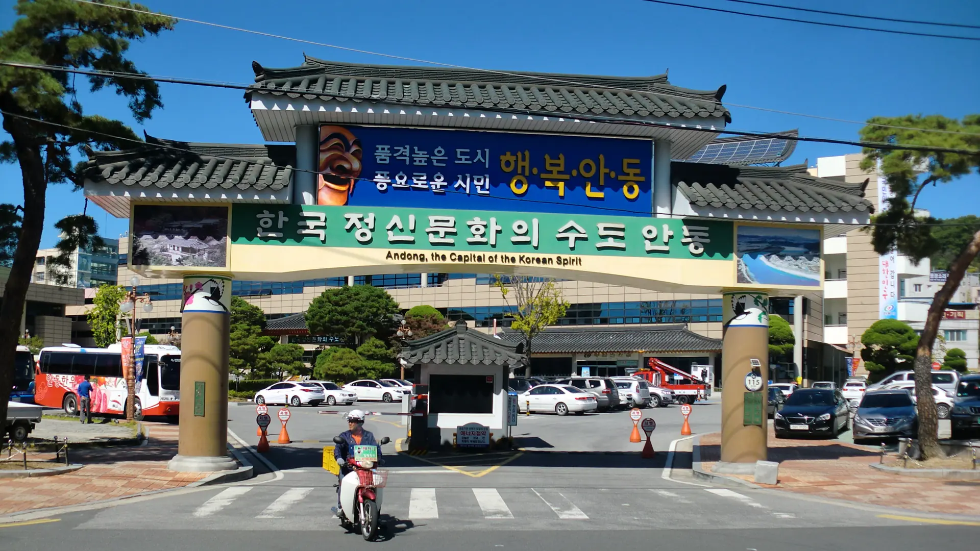 The 'Andong, the Capital of the Korean Spirit' gateway arch over a downtown Andong street, in bright daylight