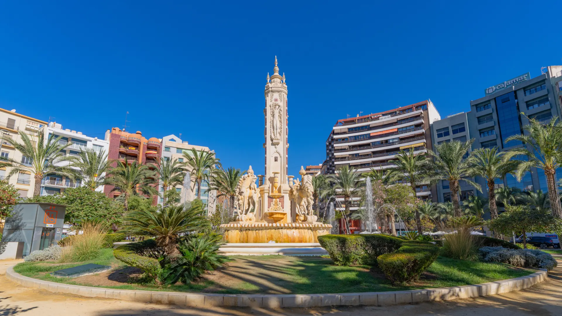 Luceros fountain, with horse sculptures and palms beneath a blue Alicante sky