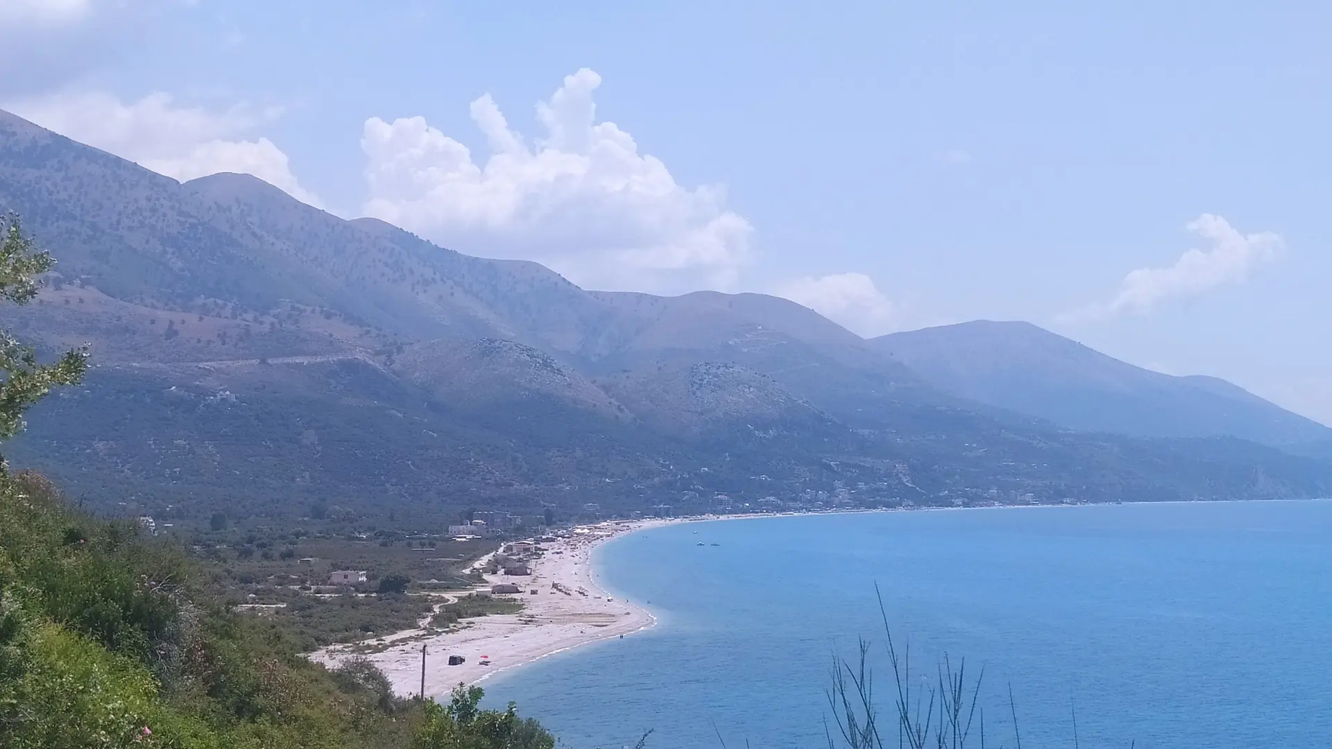 The long beach and blue bay at Borsh seen from Qeparo on the Albanian Riviera on a sunny day