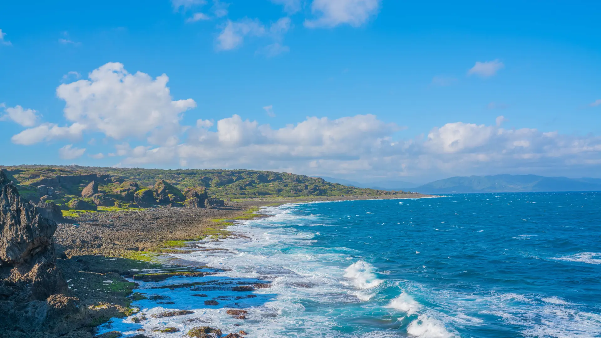 Turquoise Okinawan sea, pale coral beach and green subtropical coast in full sunshine