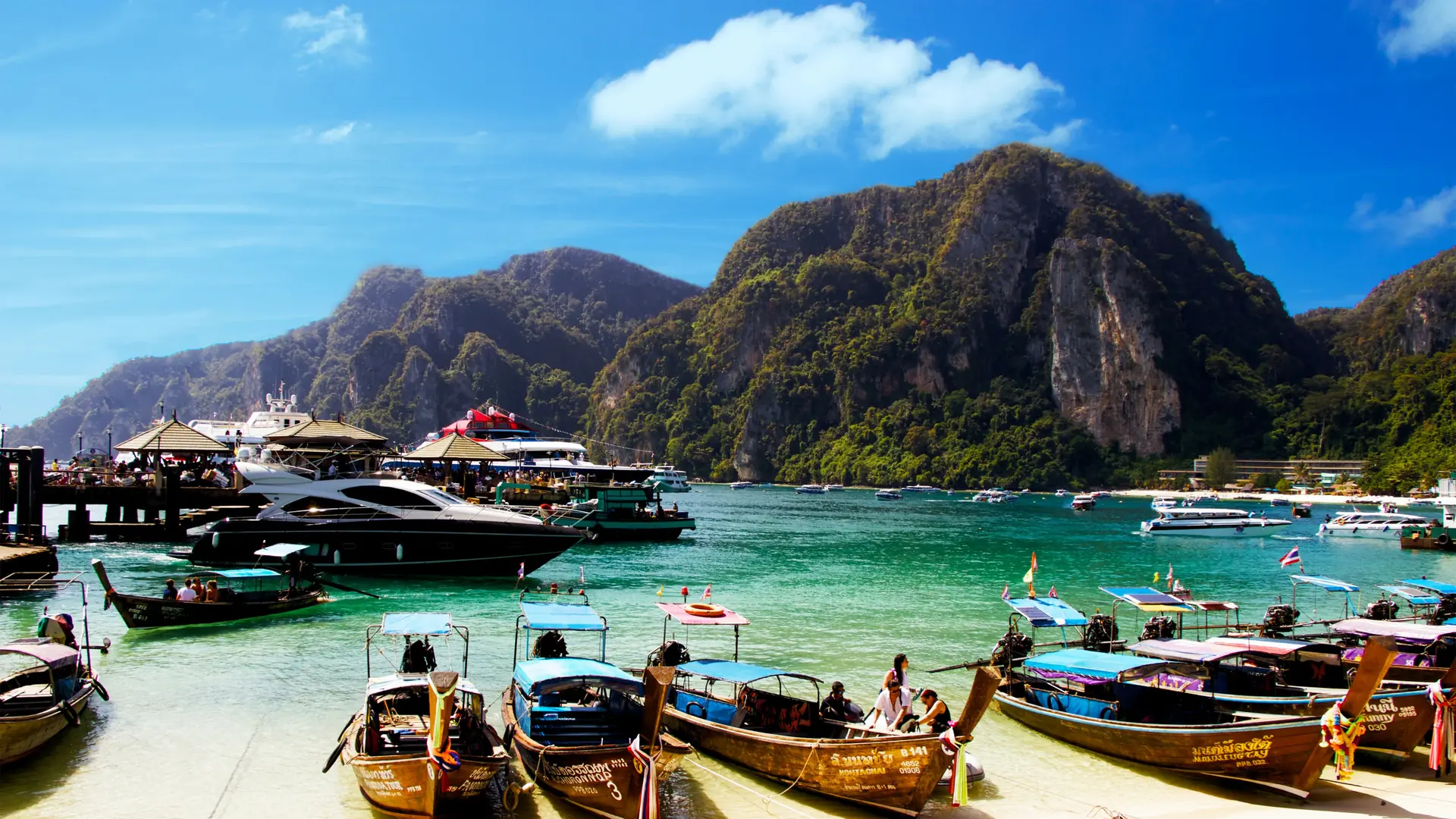 Longtail boats and the green cliffs around Tonsai Bay on Phi Phi Don