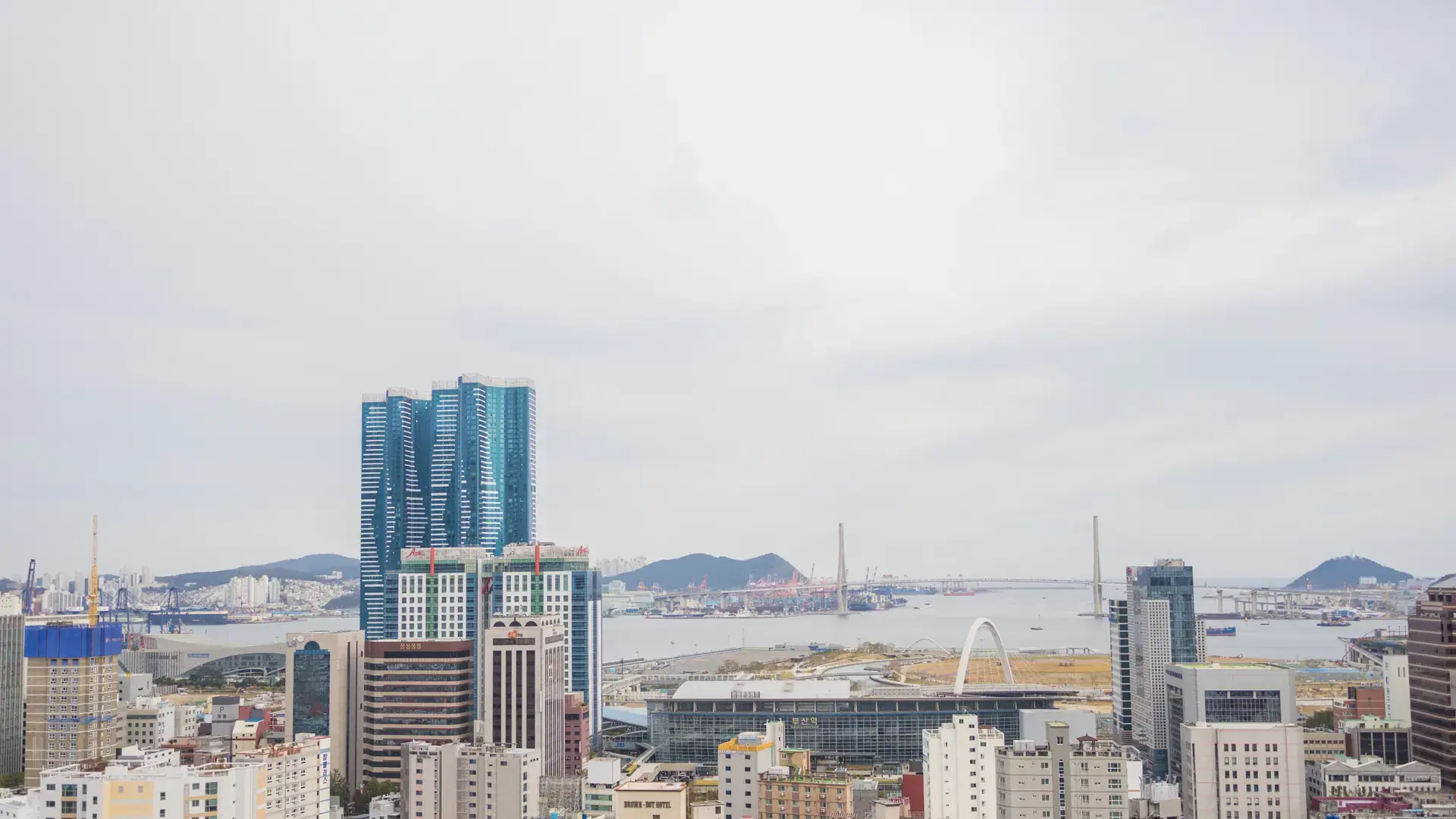 Busan's skyline with the LCT tower and harbour bridge under overcast daylight