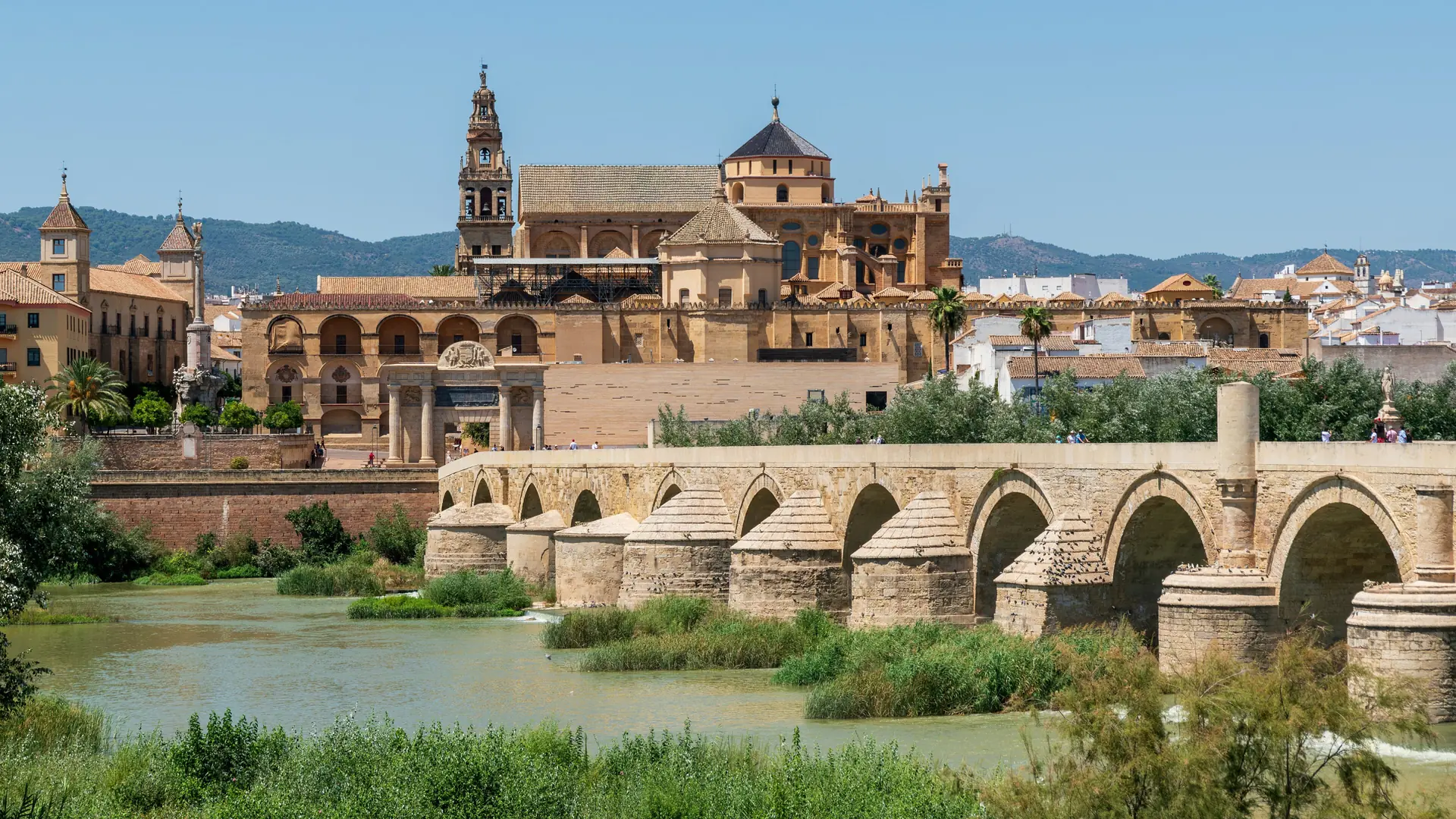 Roman Bridge across the Guadalquivir below the Mosque–Cathedral and Puerta del Puente in sunny Córdoba