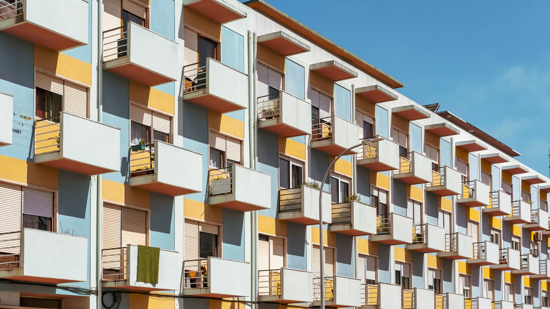 colourful balconied apartment facades under a bright blue sky in Catania