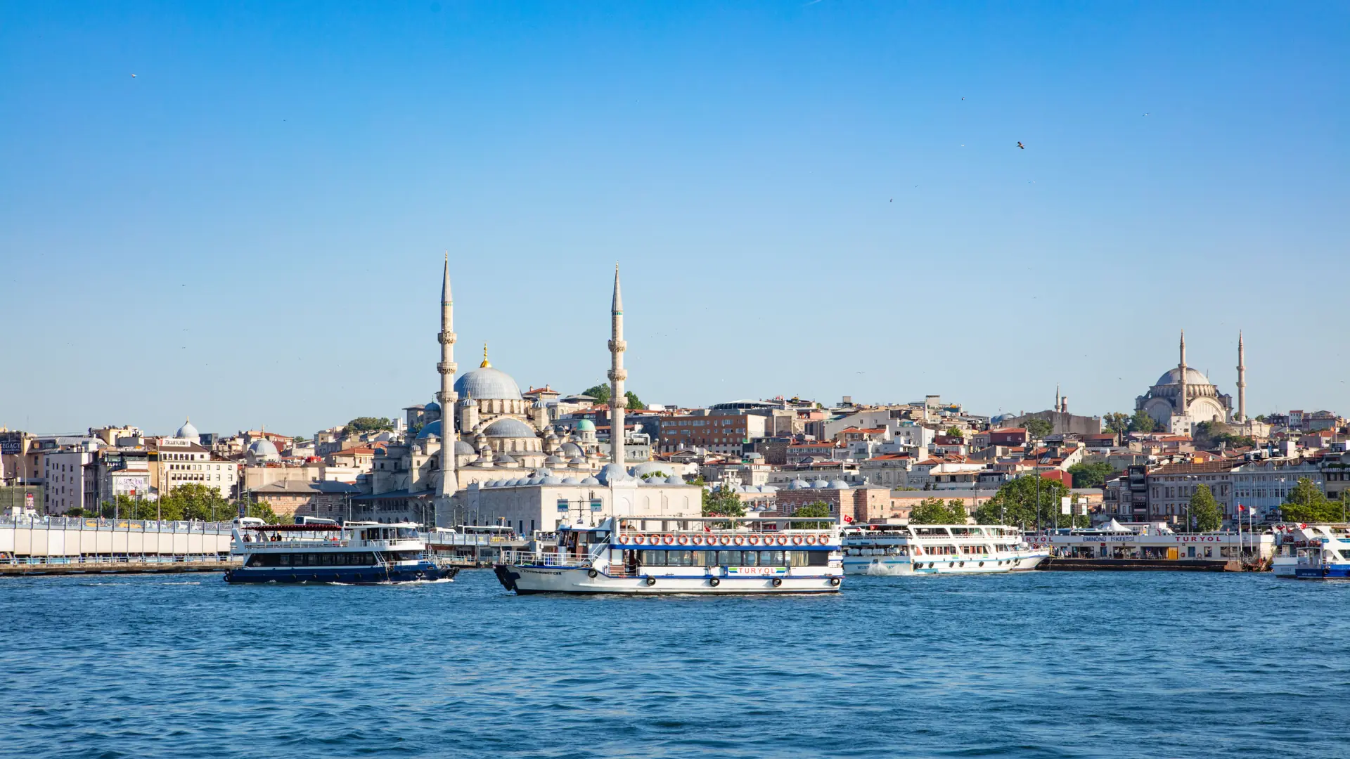 Ferries on Istanbul’s Golden Horn in front of the New Mosque and historic skyline