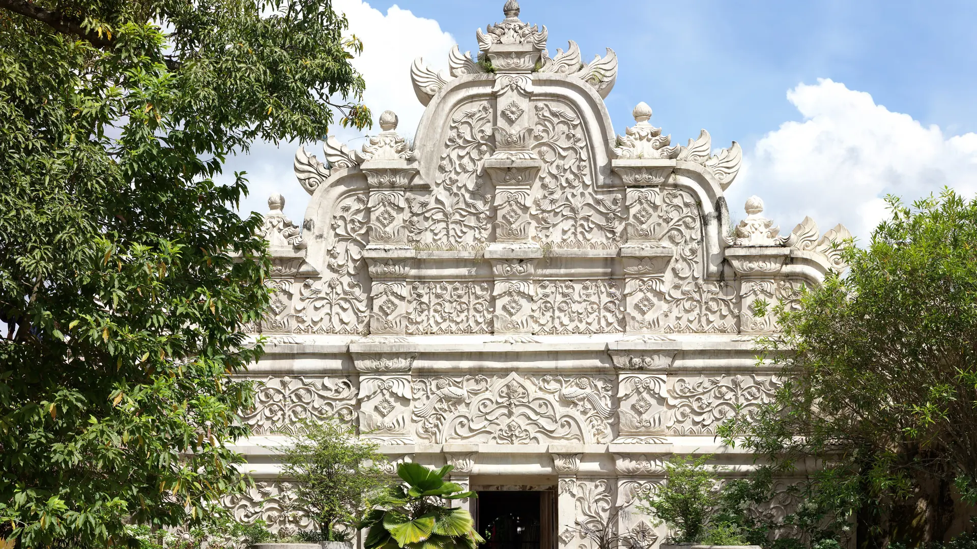 Carved western gateway of Taman Sari in Yogyakarta, shown as a wider city heritage scene