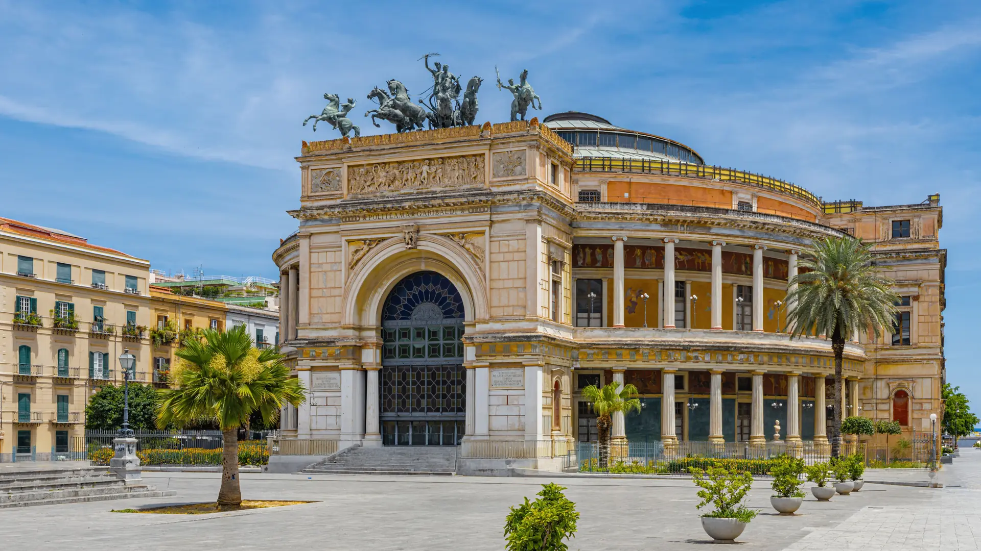 bright Politeama square in Palermo with grand theatre façade, palm trees and broad boulevard