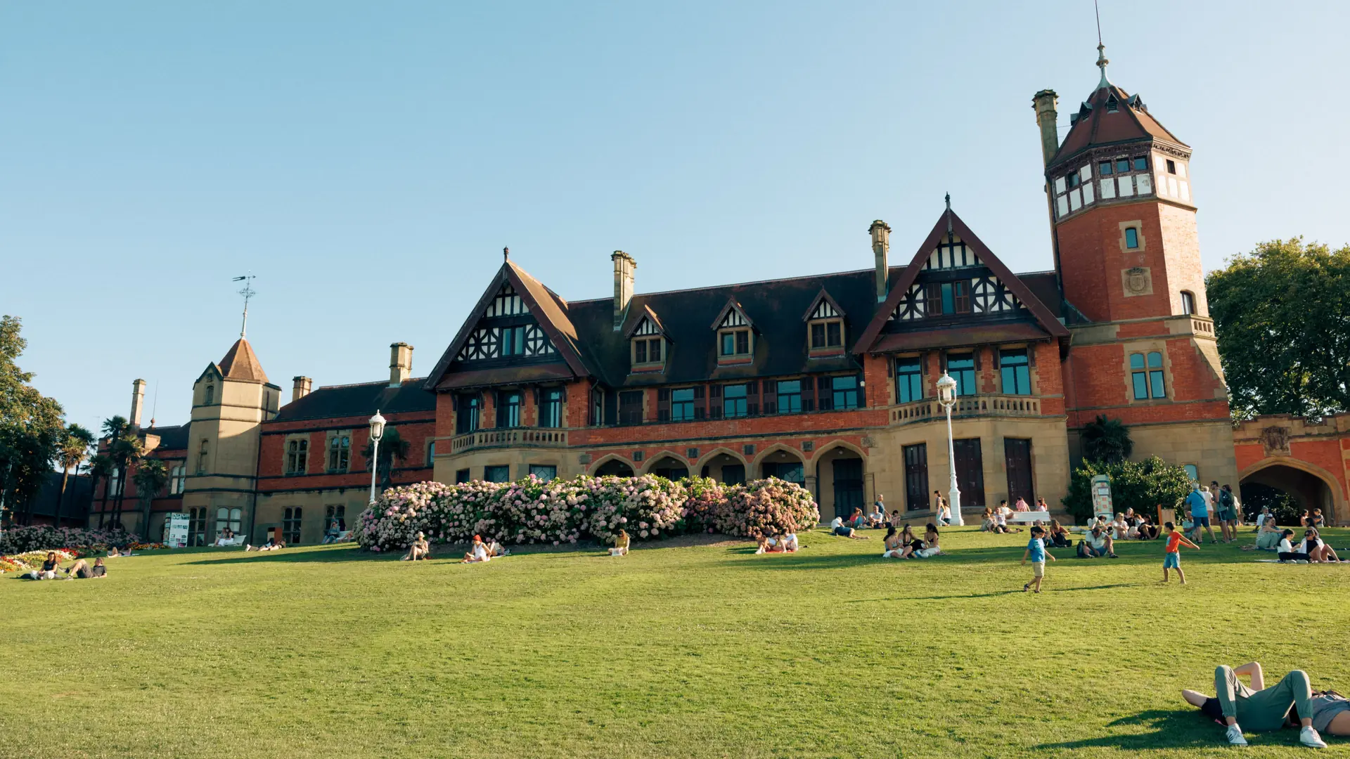 Miramar Palace’s red brick, timbered gables and tower above its sunlit lawn in San Sebastián