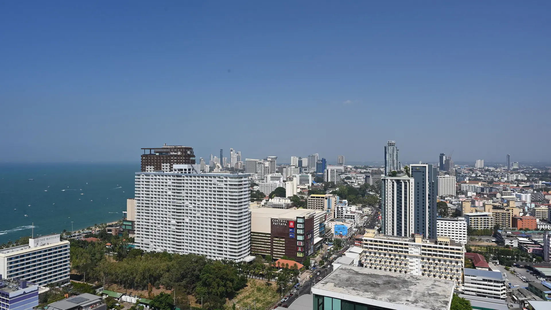 Sunlit Pattaya skyline beside the blue Gulf of Thailand