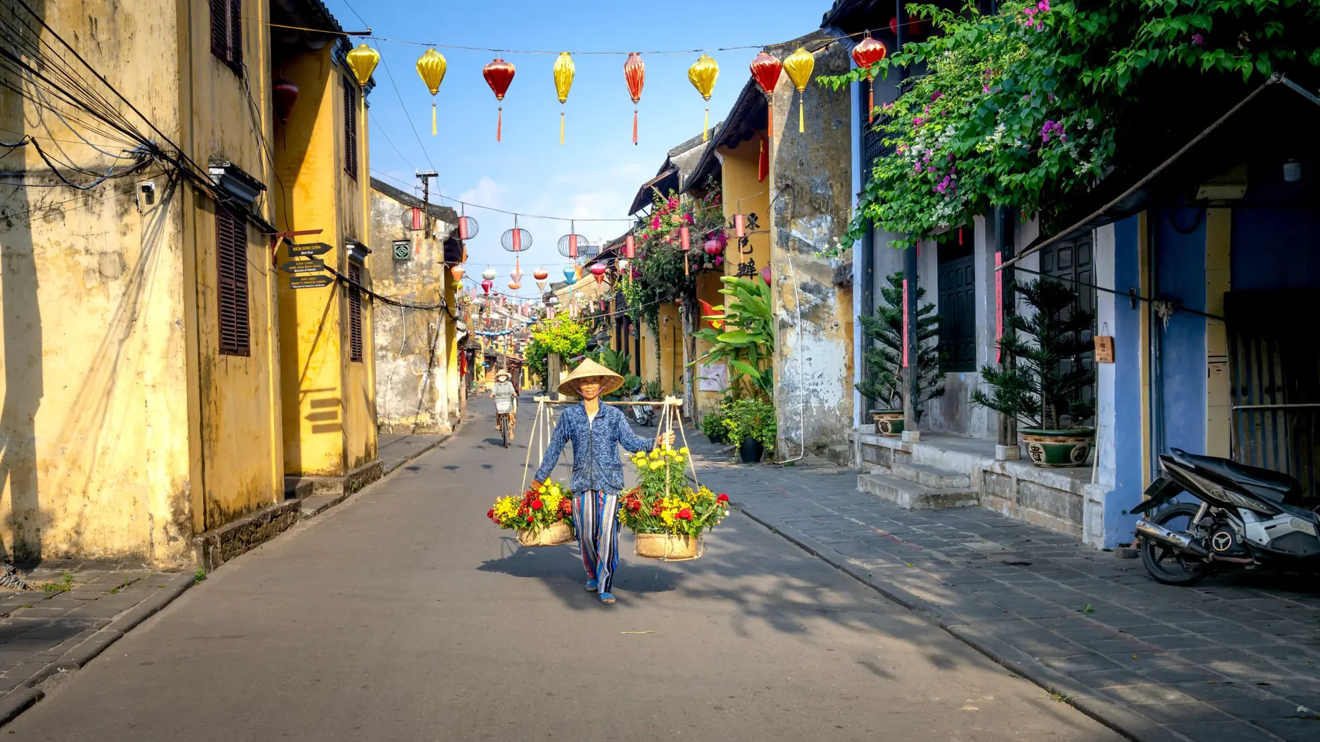 Hoi An flower seller beneath colourful street lanterns