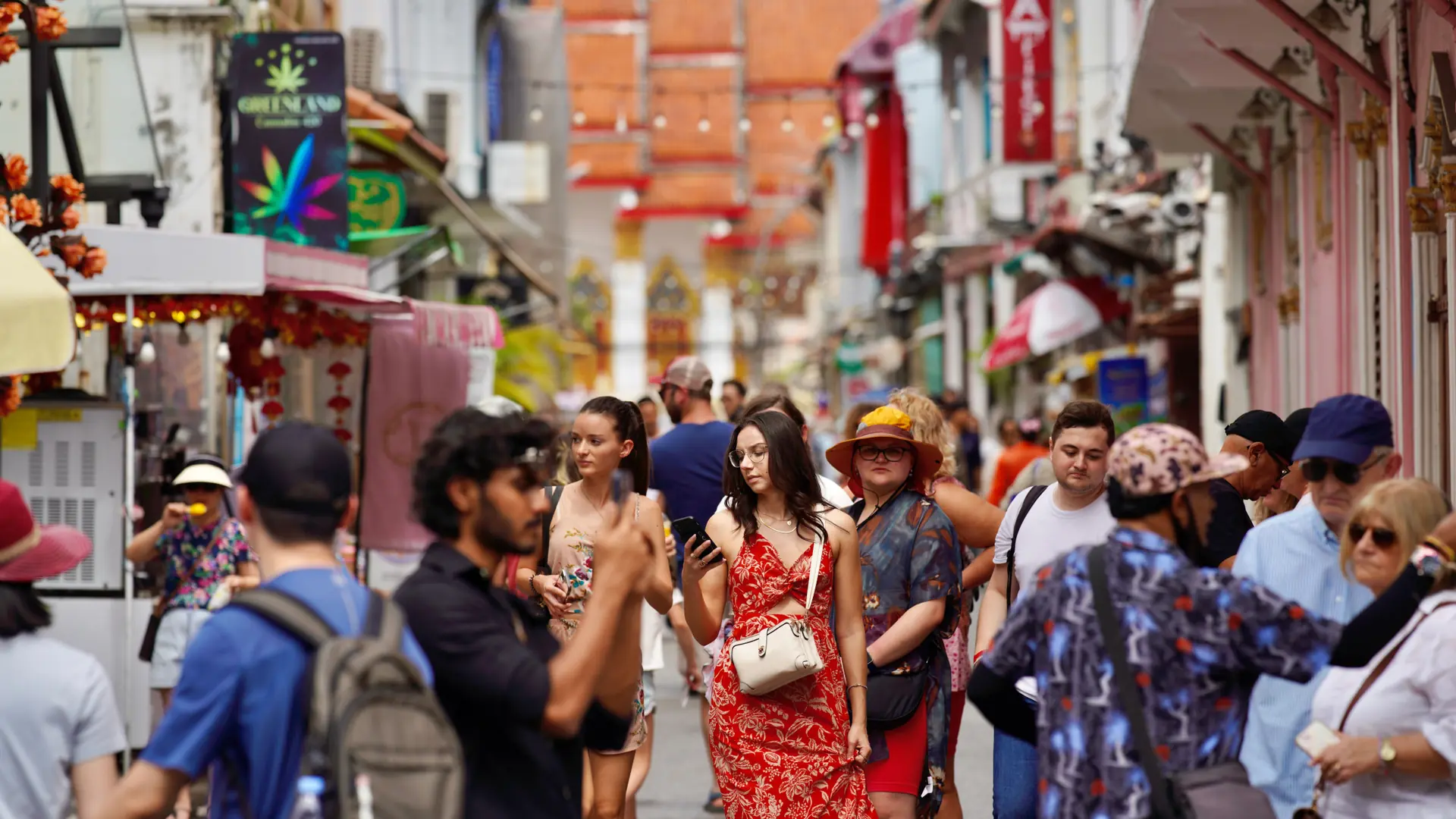 Travellers crossing a lively street lined with Sino-Portuguese buildings in Phuket Town