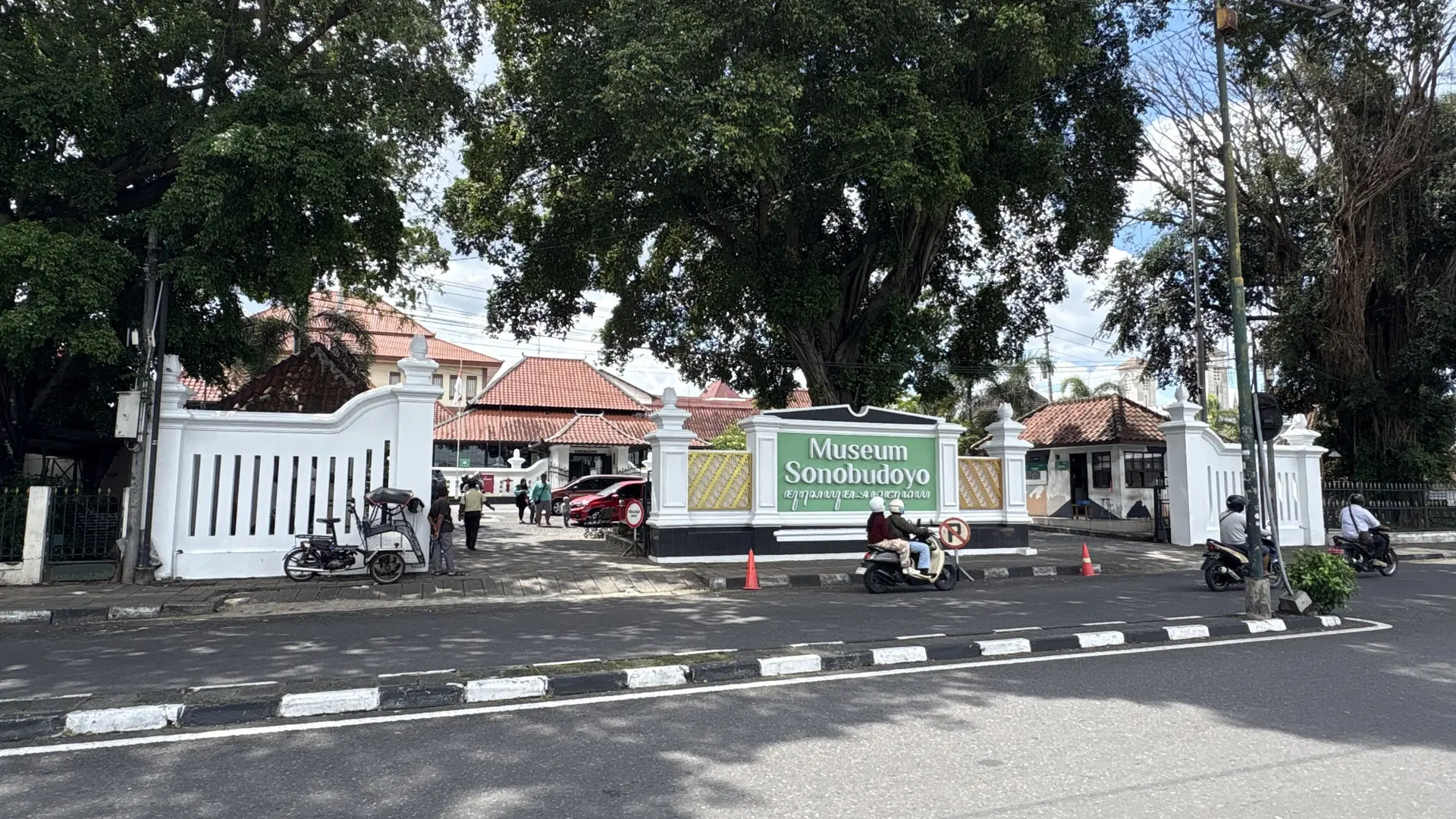 Entrance to Sonobudoyo Museum in Yogyakarta, with its green sign, white walls and red tiled roof
