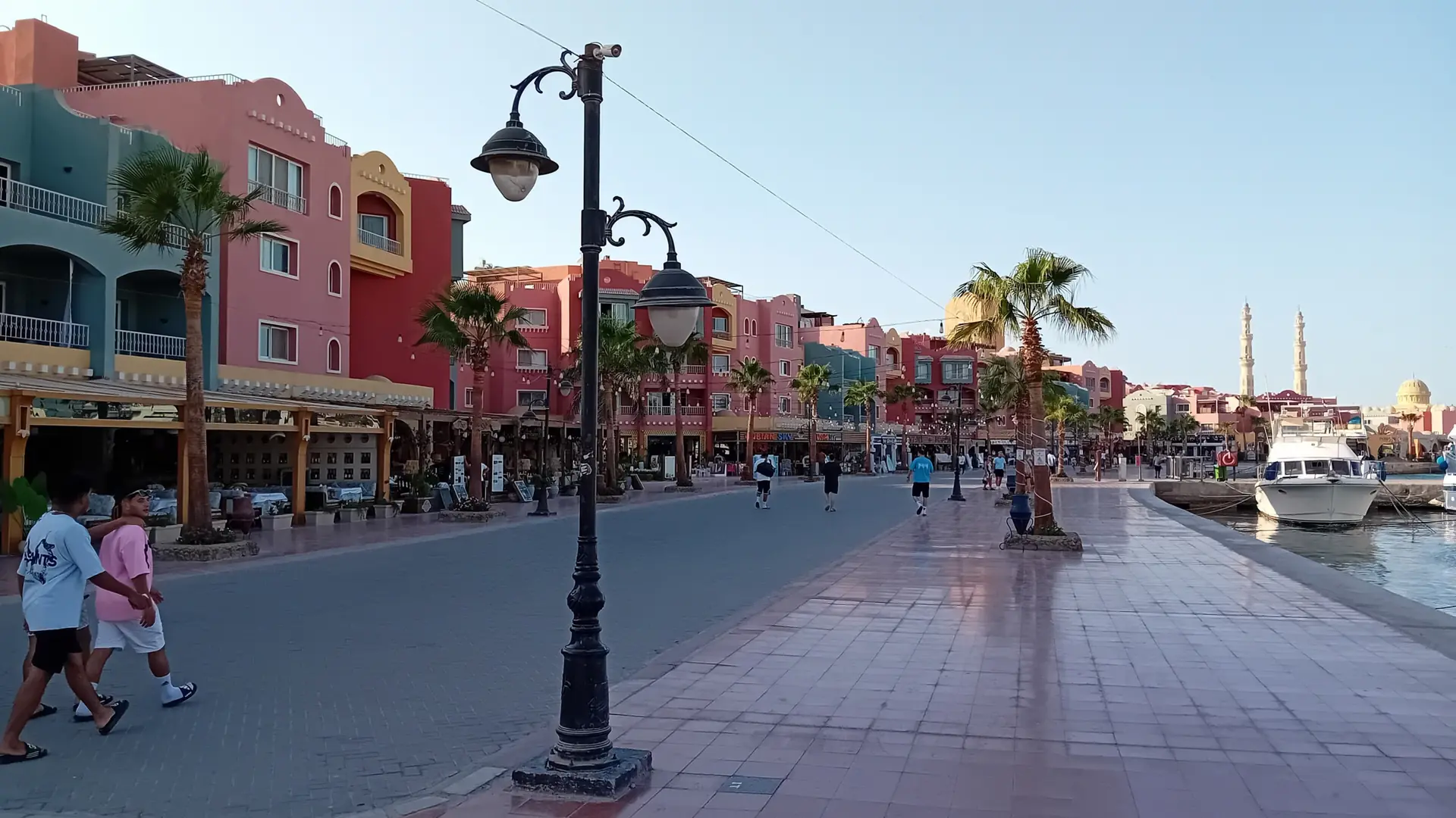 Hurghada Marina promenade beside colorful buildings and moored boats