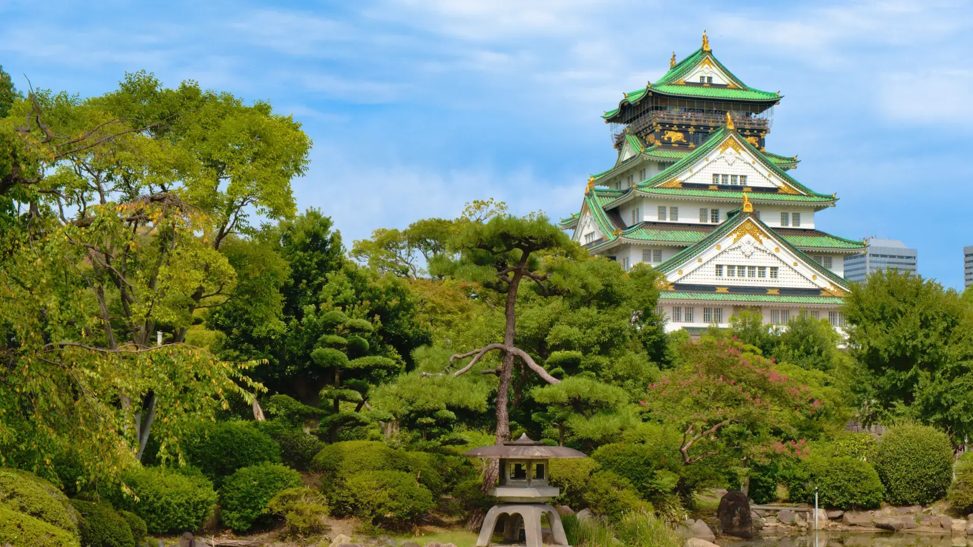 Osaka Castle above green parkland in brilliant daylight