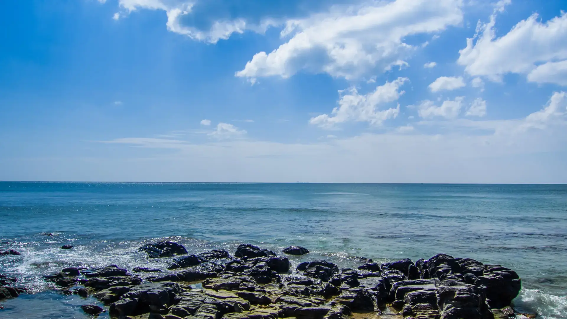 Blue Andaman water meeting a rocky Koh Lanta shoreline