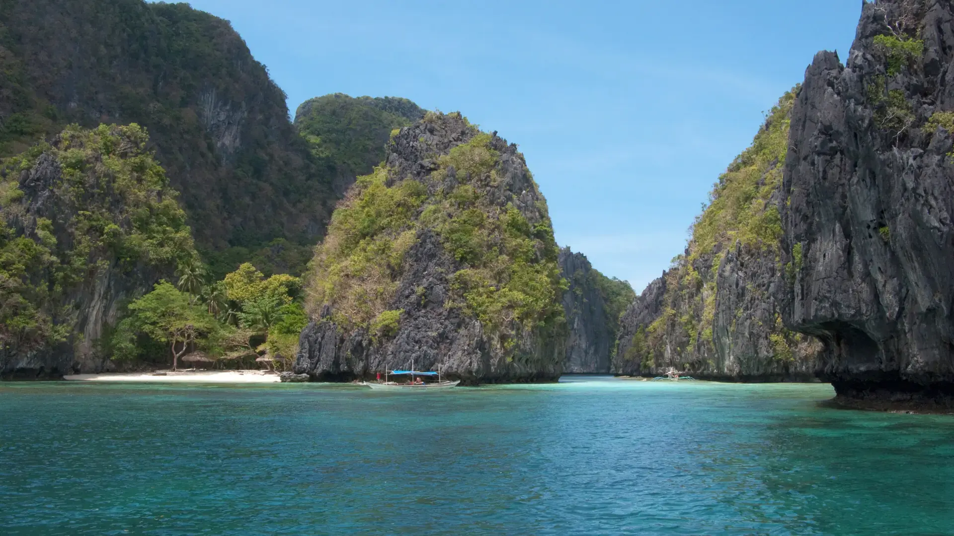 A turquoise lagoon between limestone cliffs in Bacuit Bay, El Nido