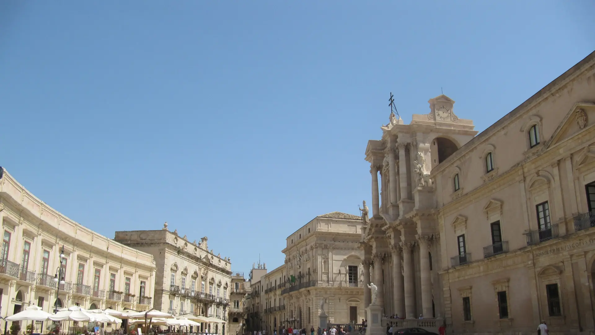 Piazza Duomo in Ortigia, with Syracuse Cathedral and pale stone palaces in daylight.