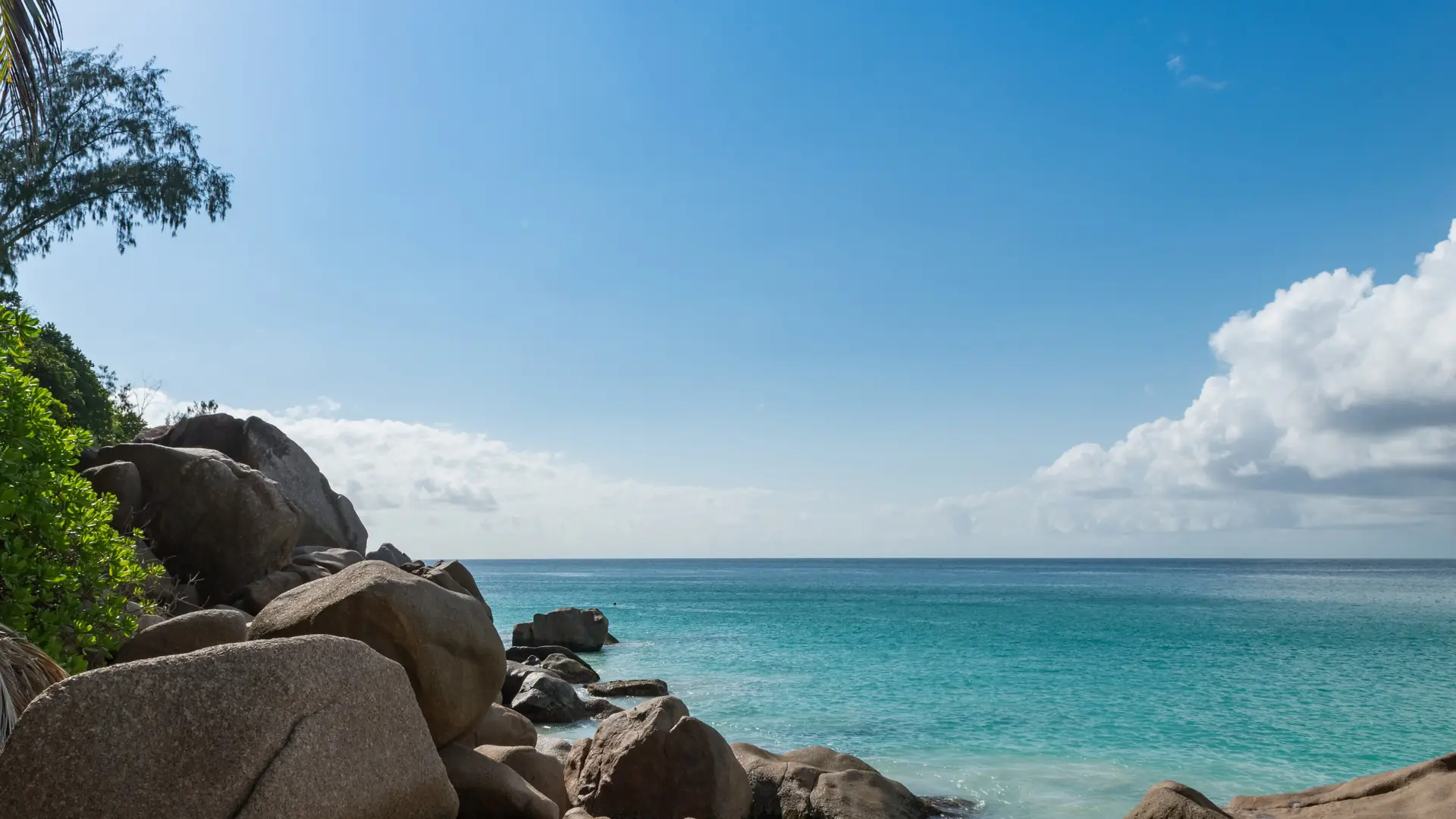 Granite rocks and blue sea along a sunny Seychelles coast
