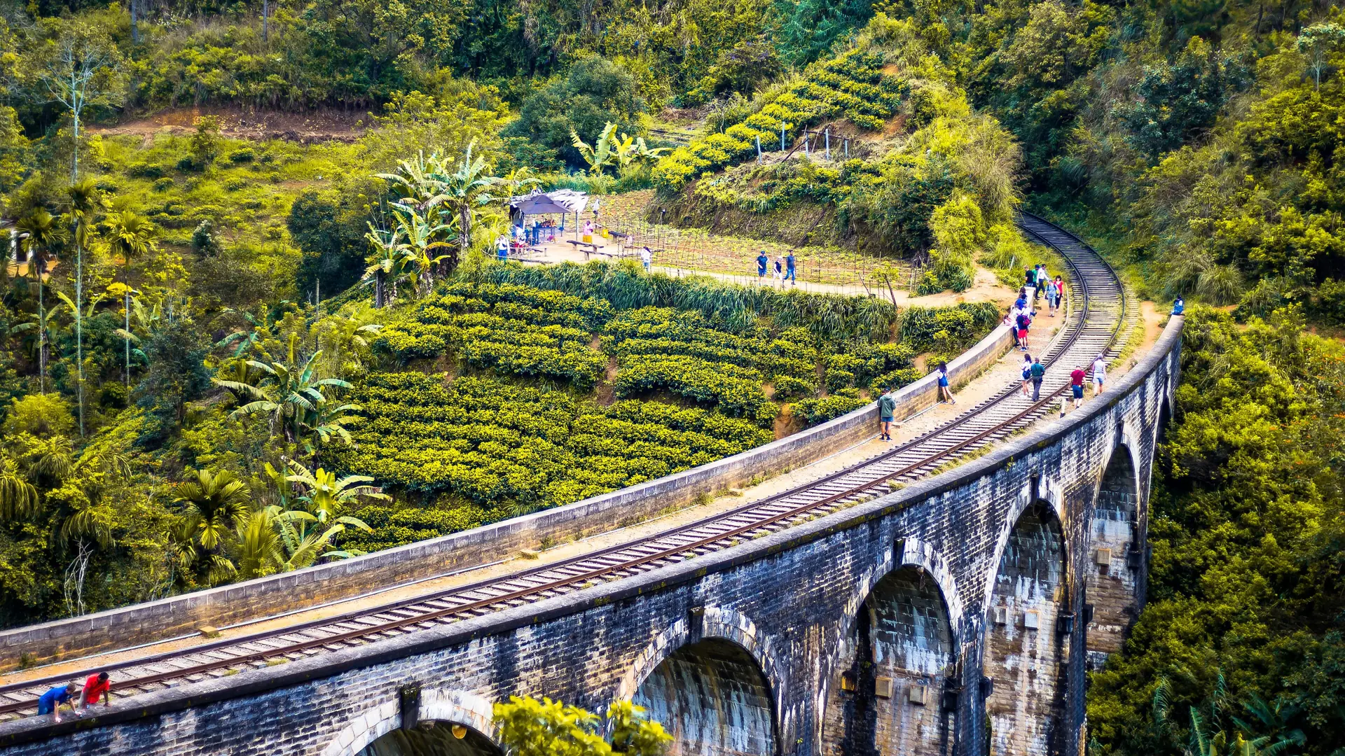 Nine Arch Bridge curving through a green hillside near Ella