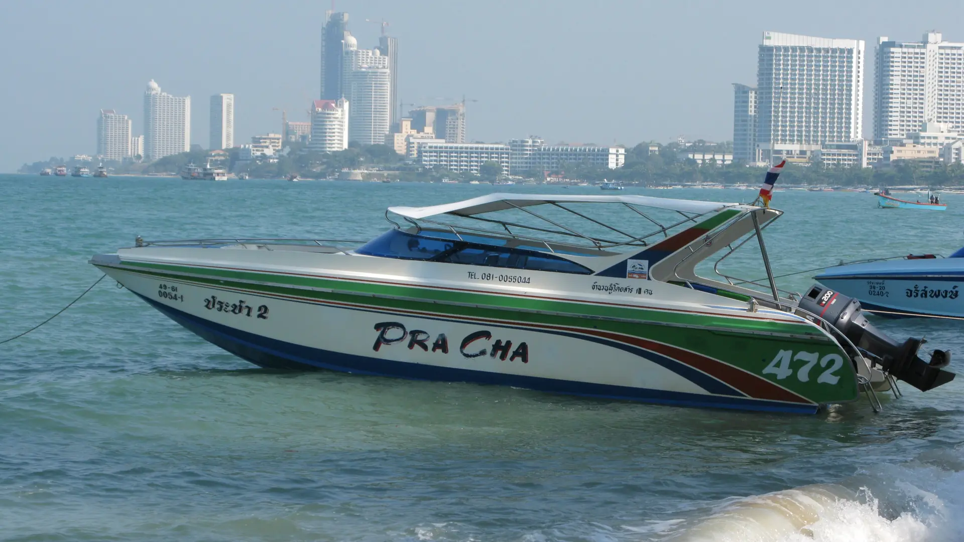 A speedboat on Pattaya Bay with the city behind it, rather than Na Jomtien