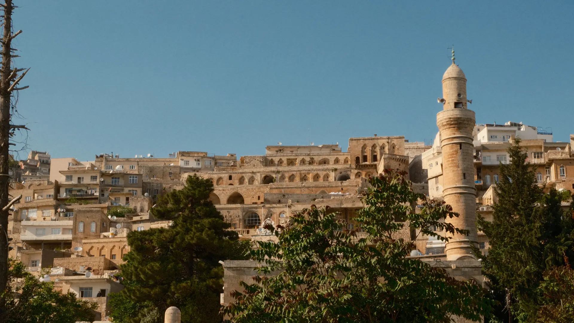 Mardin stone houses and minaret layered across the hillside