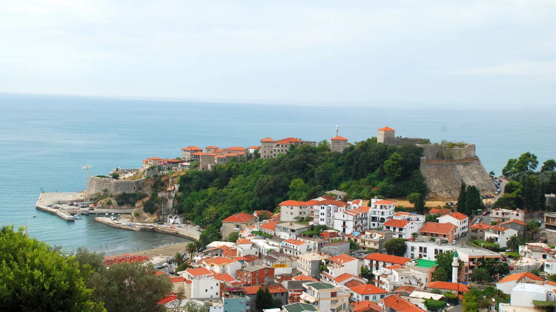 Ulcinj Old Town on its rocky headland above the blue Adriatic and red-roofed houses