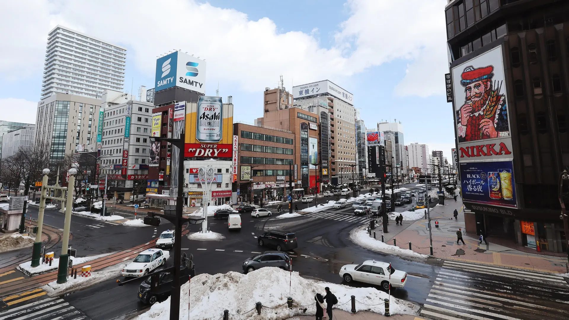 The Nikka sign above Susukino’s broad crossing, with snow beside Sapporo’s winter streets.