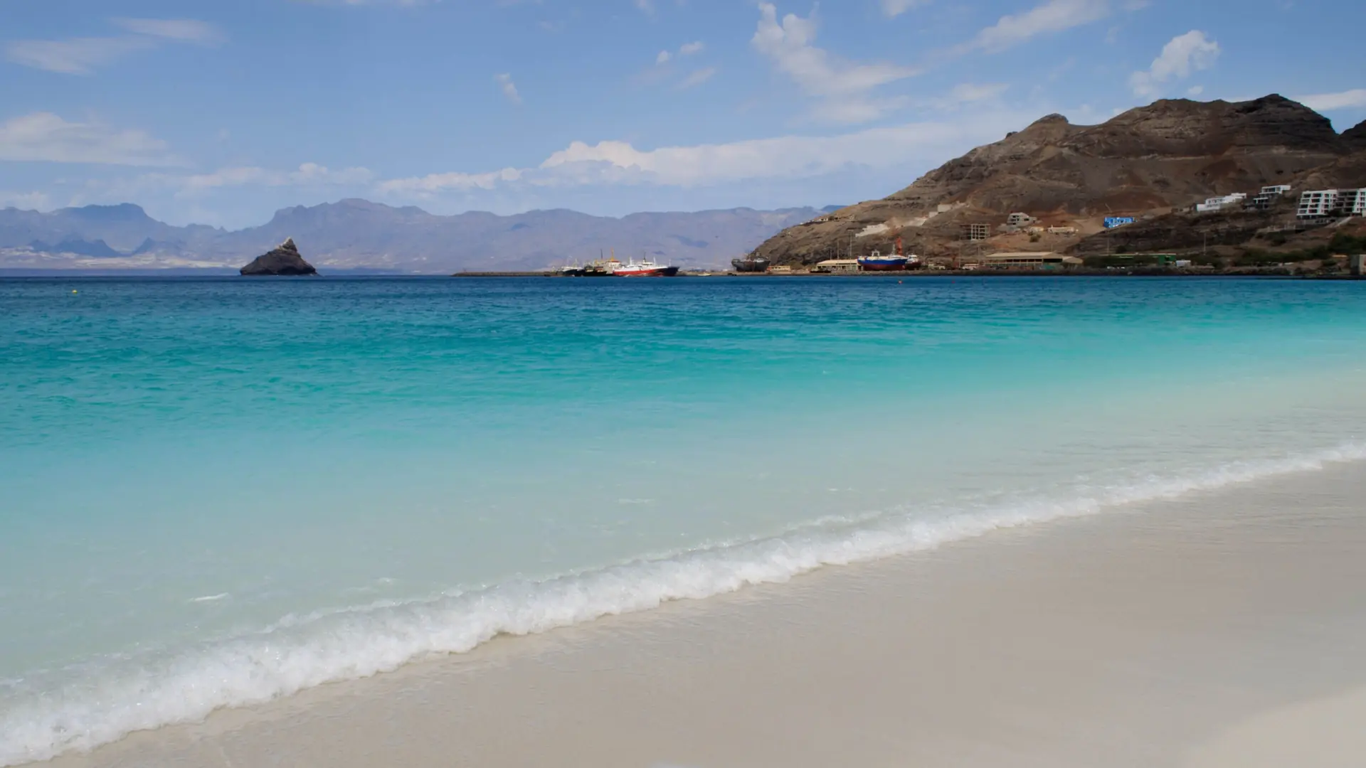 Sunlit Laginha beach, clear water and São Vicente hills beside Mindelo