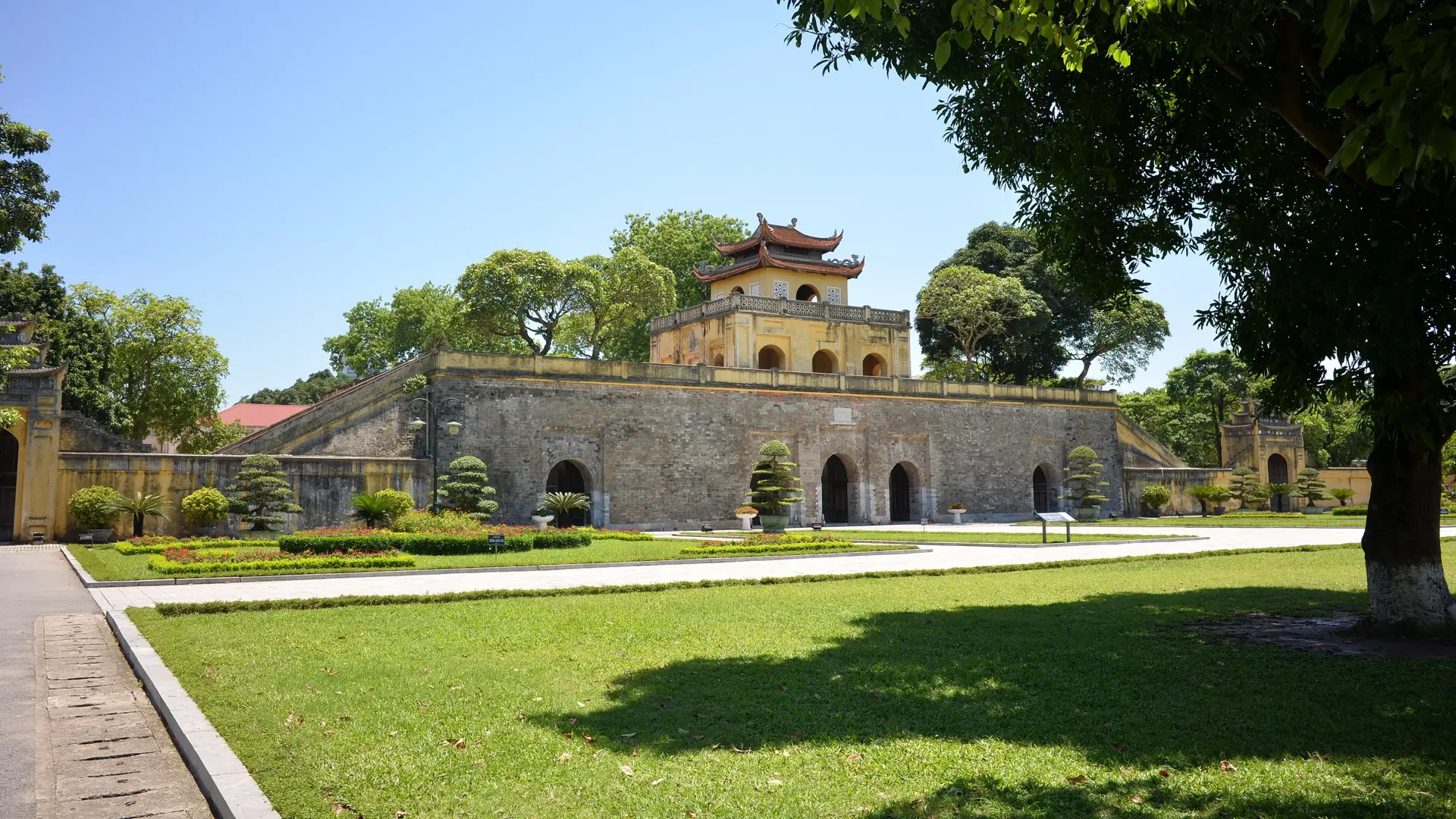 Doan Gate at Thang Long Citadel with green lawns beneath a blue sky in Hanoi.