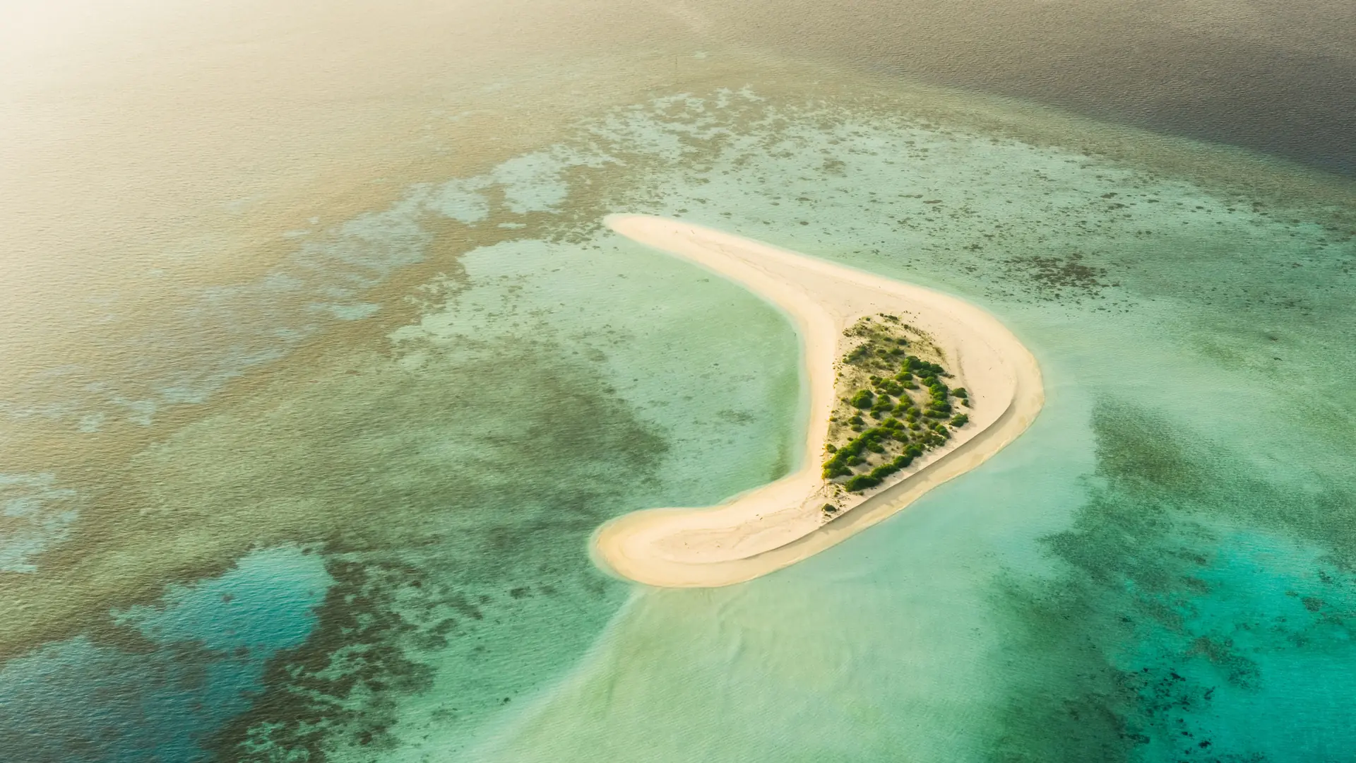 Aerial view of a small white sandbank in the Maldives