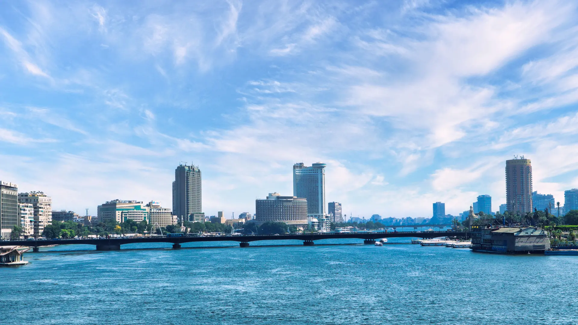 Bright Nile river and Cairo city skyline under a blue sky