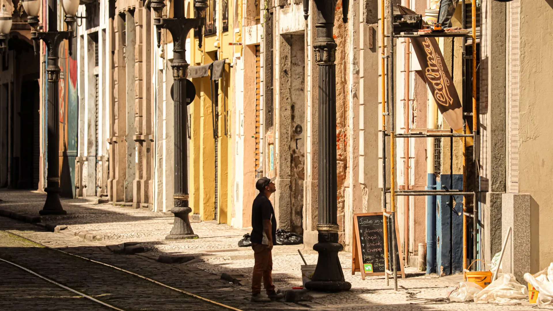 a sunlit colonnaded street in central Funchal with warm-toned historic façades