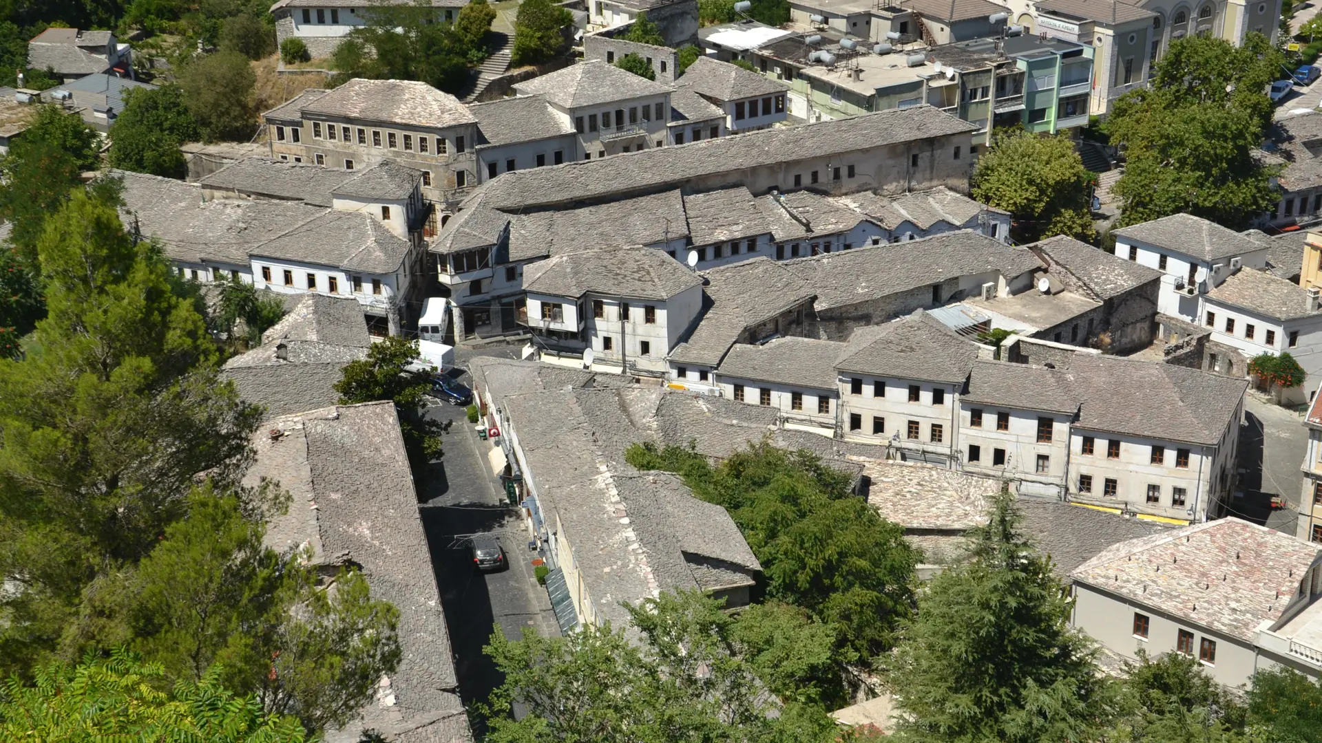 Stone-slab roofs and tower houses of Gjirokastër's old town in sunshine