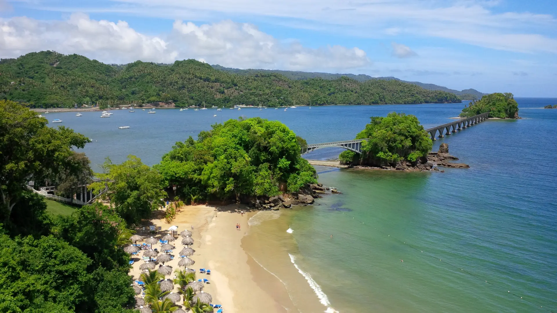 Sunny Playa Los Cayos and footbridge beside Samaná Bay