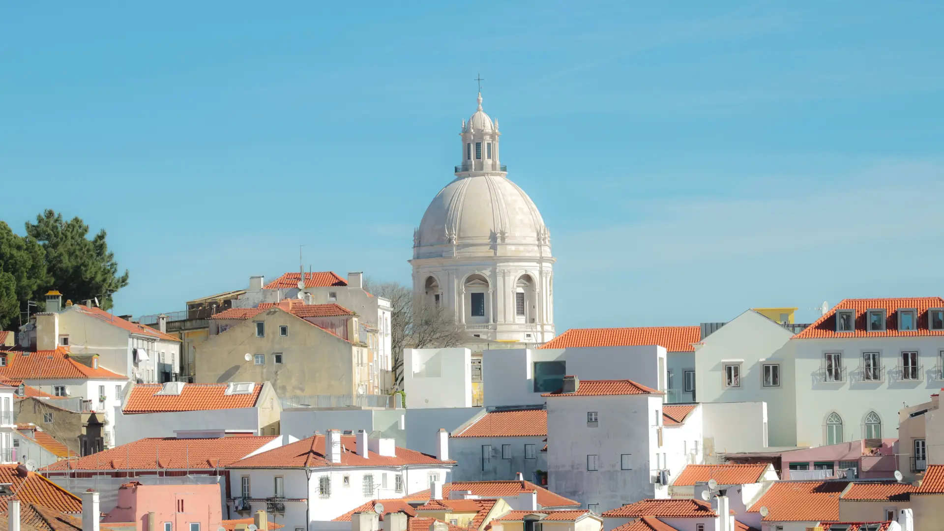 Alfama's red-tiled rooftops in Lisbon with the National Pantheon dome rising above them