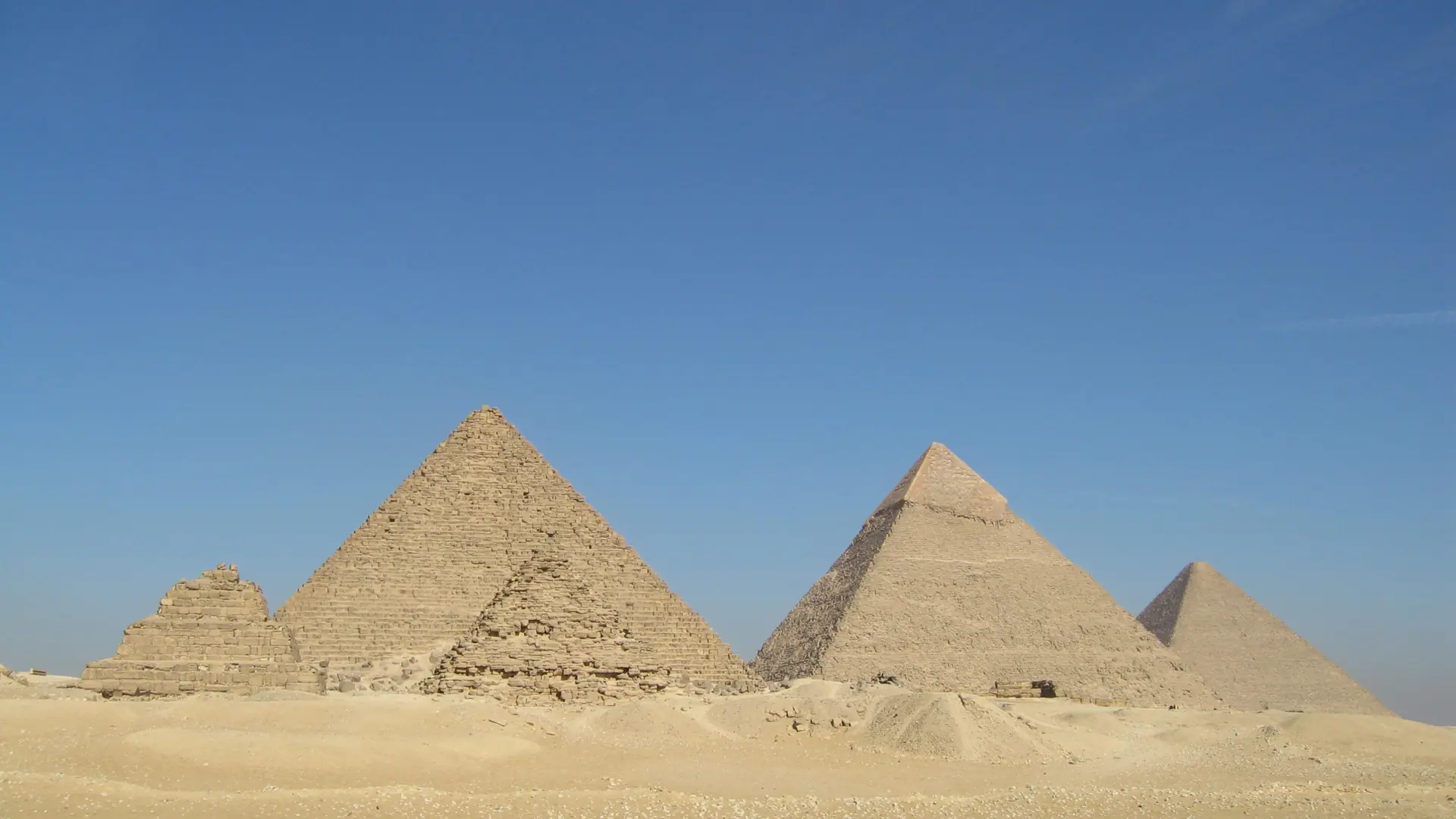 Sunlit Giza pyramids rising over the desert plateau near Cairo.