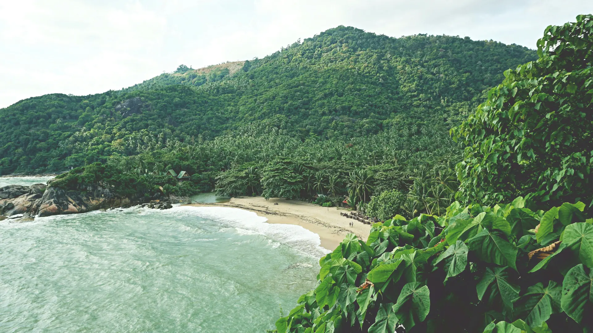 A bright tropical beach and clear shallows on western Koh Phangan