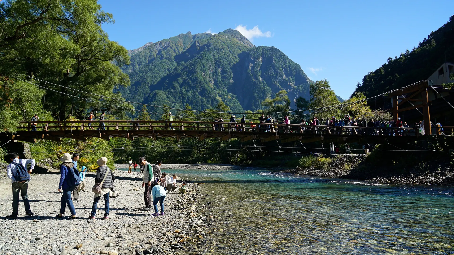 Clear Azusa River beneath forested peaks in Kamikochi