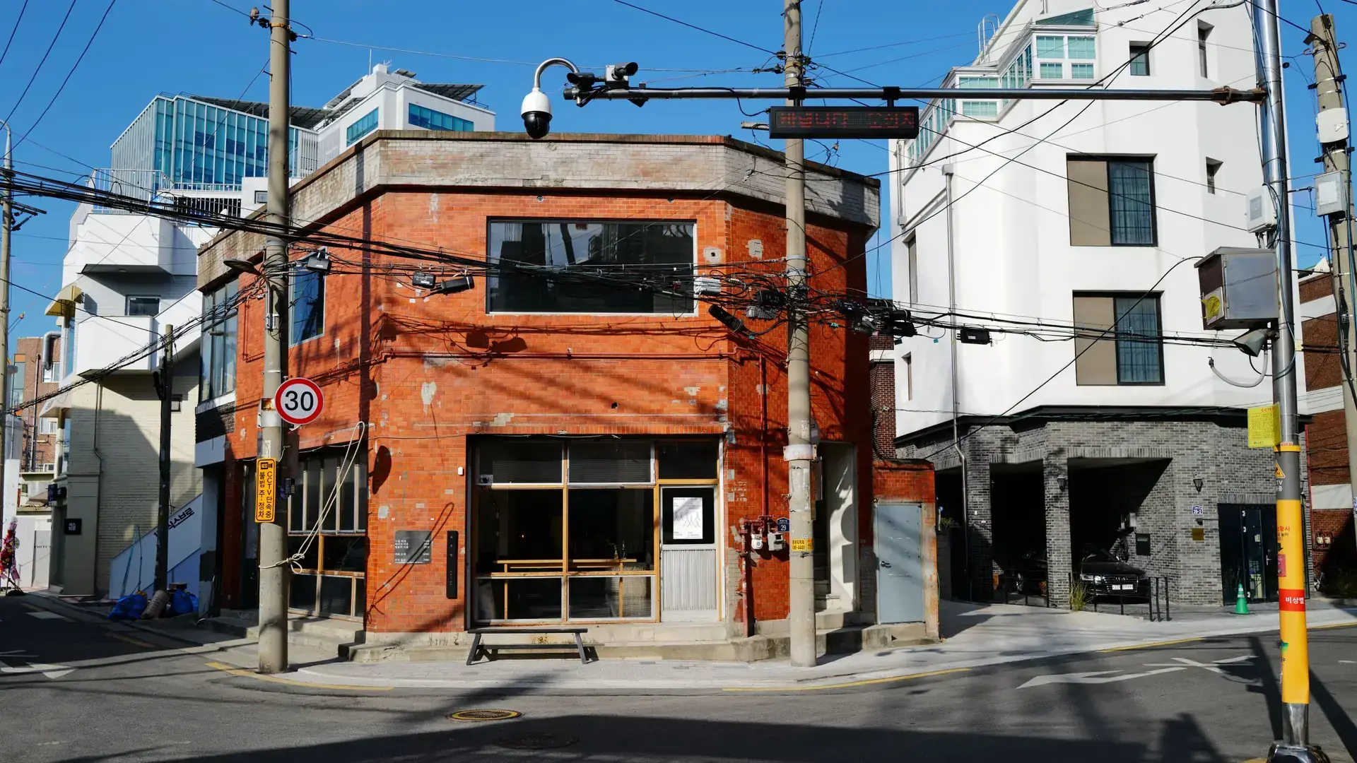 A sunlit street corner with colorful brick architecture in Seoul