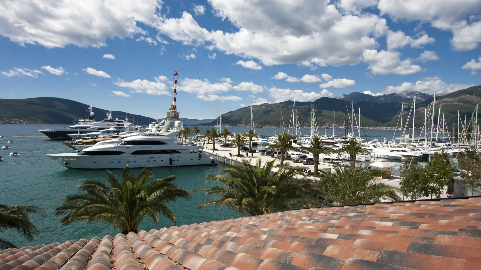 Yachts in Porto Montenegro marina at Tivat, with the town and steep hills beyond